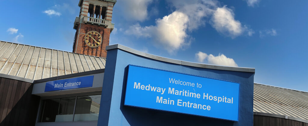 Close up of the Medway Maritime Hospital main entrance sign and clocktower