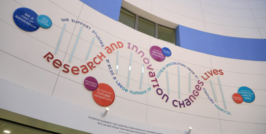 A large mural on the wall which reads 'Research and Innovation changes lives'